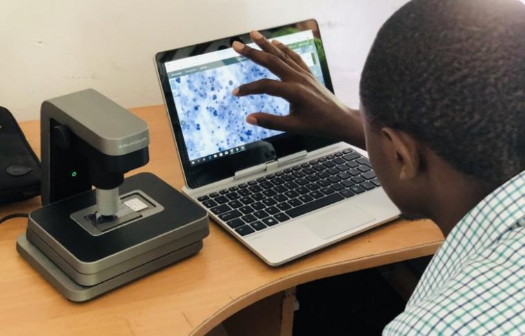 Lab manager Martin Muinde scans pap smears at the Kinondo Clinic in Kenya.