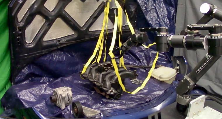 A robot performs the difficult to model task of manipulating straps without...