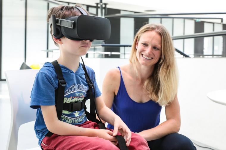 Jenifer Miehlbradt with a 6 year old child trying out the virtual reality games.