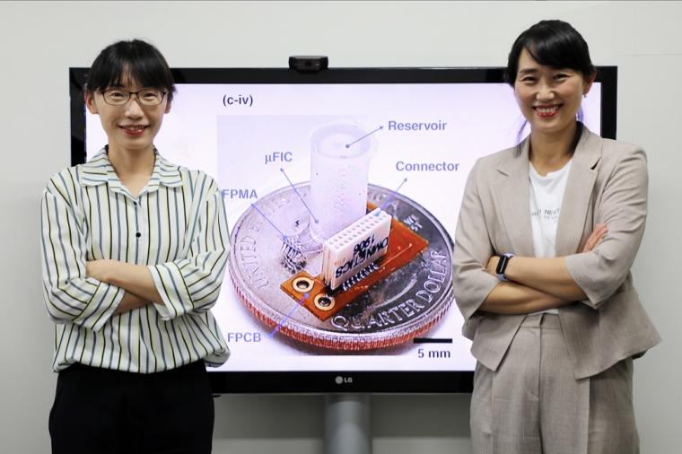 The scientists standing in front of an image of their flexible neural interface
