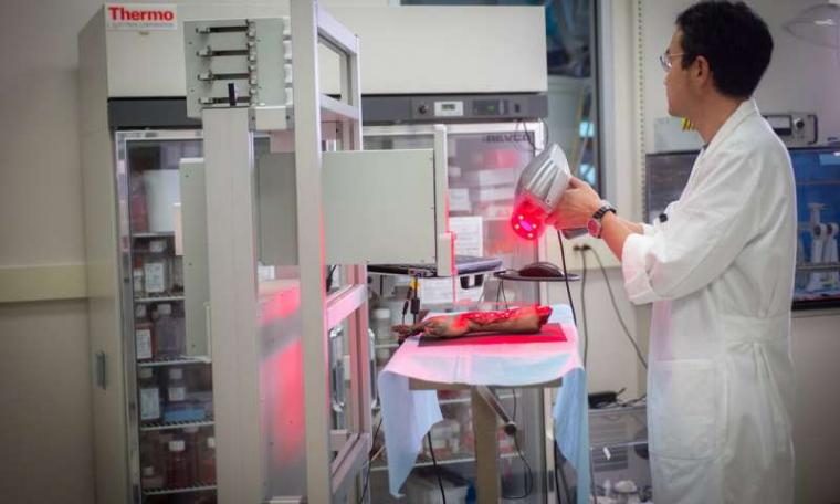 A mobile skin bioprinter operated on a demo limb by a Wake Forest Institute for...