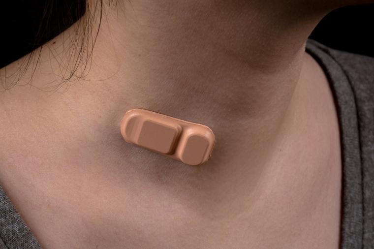 A woman wears a new wearable shunt monitor on her neck.